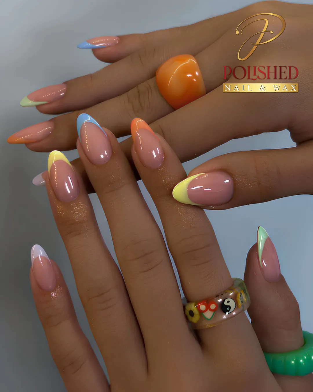 almond french tip nails with various pastel colors including blue yellow and orange