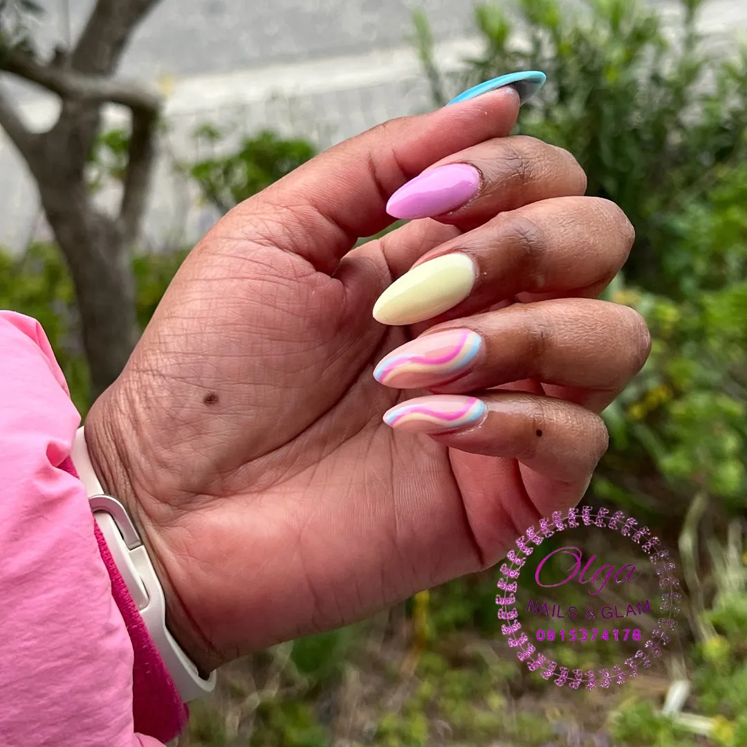 multi-colored almond nails in pastel pink, yellow, and blue with colorful swirl nail art.