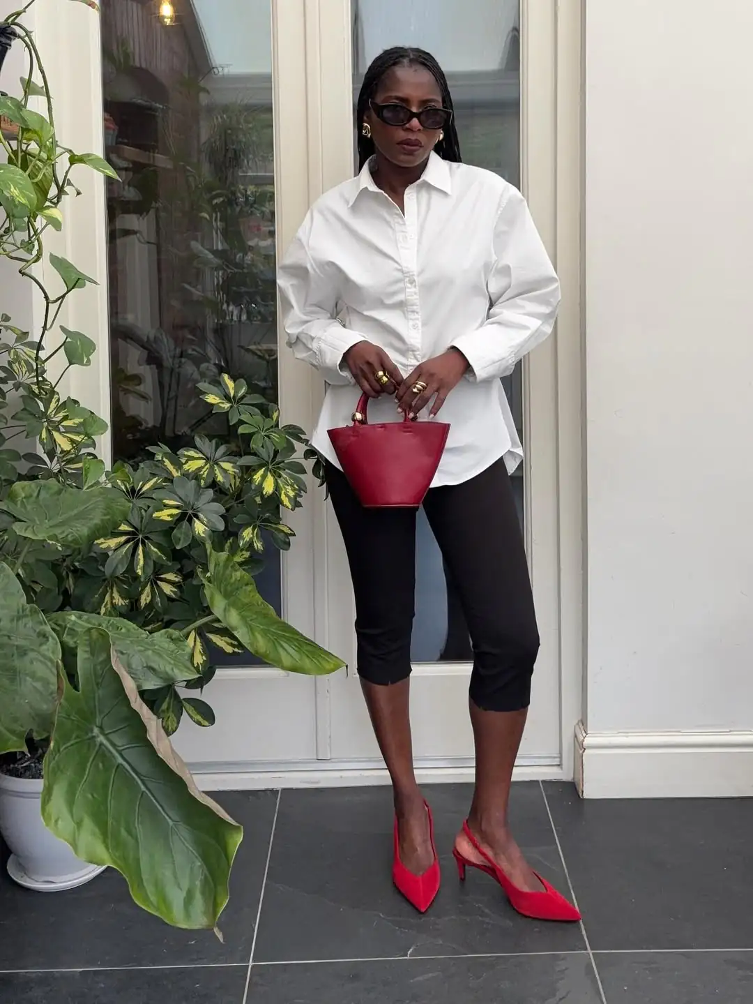 woman in white button down shirt and black cropped leggings with red heels