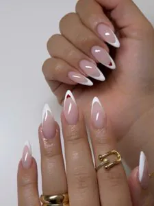 classic white french tip stiletto nails with small red heart accents