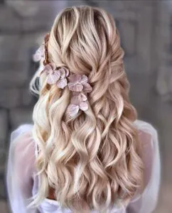 back view of wavy blonde hair with pink flower hair accessories