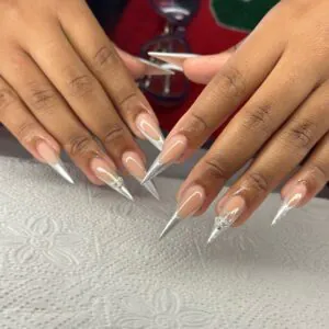 long stiletto nails with silver chrome french tips and metallic sword charms