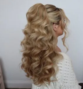 back view of woman with long voluminous blonde waves and half updo