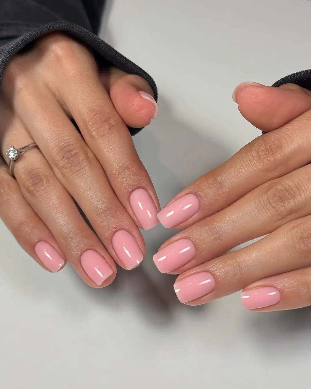 short square glossy light pink nails on hands with a diamond ring