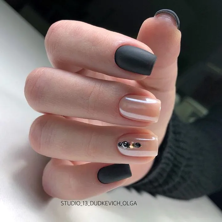 matte black and pearlescent nude nails with small black gems