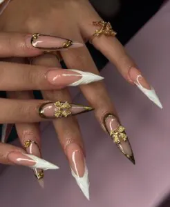 long stiletto nails with white 3d tips and gold butterfly accents