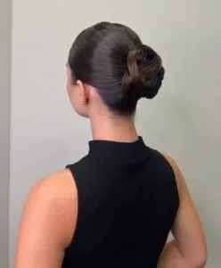 back view of woman with sleek dark hair in a sculpted bun