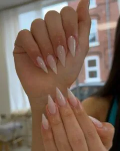 long sharp stiletto nails with a milky white translucent finish