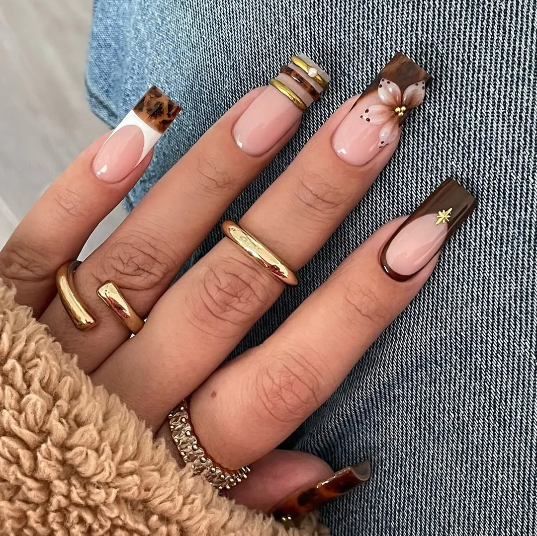 long square gel nails with brown tortoiseshell tips and a painted floral accent