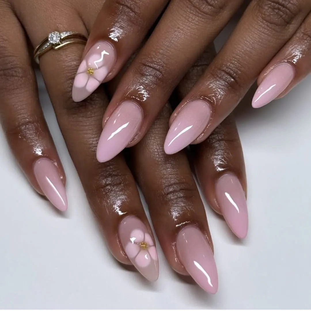 glossy almond gel nails in light pink with delicate white flower accent art
