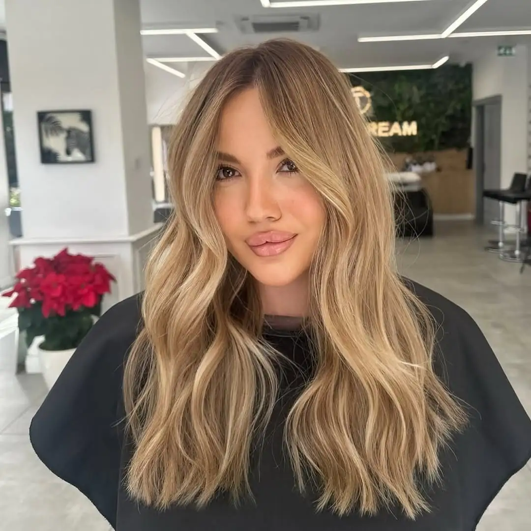 woman with sun kissed blonde hair and loose waves in a bright salon