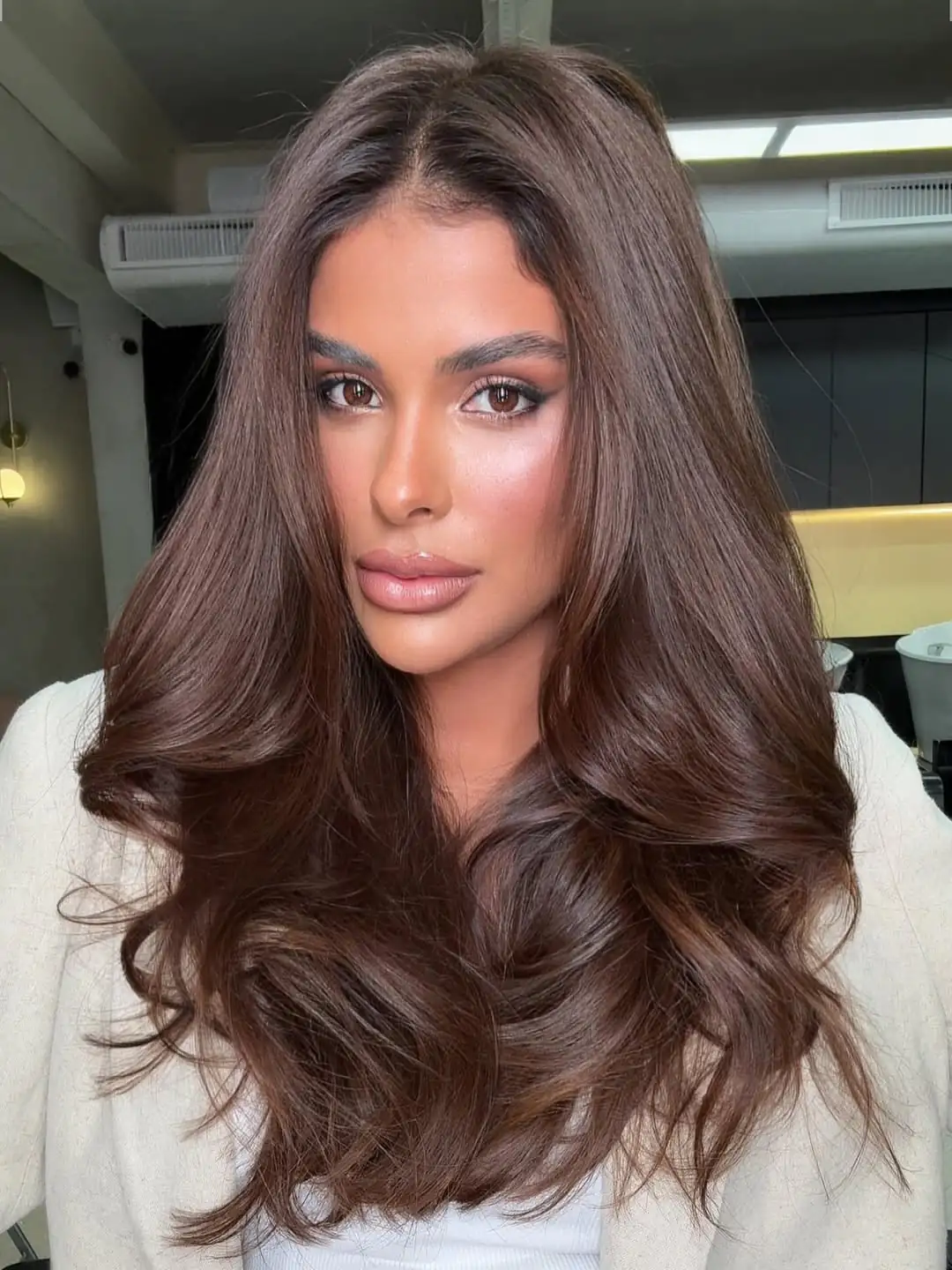 woman with long dark chocolate brown hair styled in soft voluminous curls