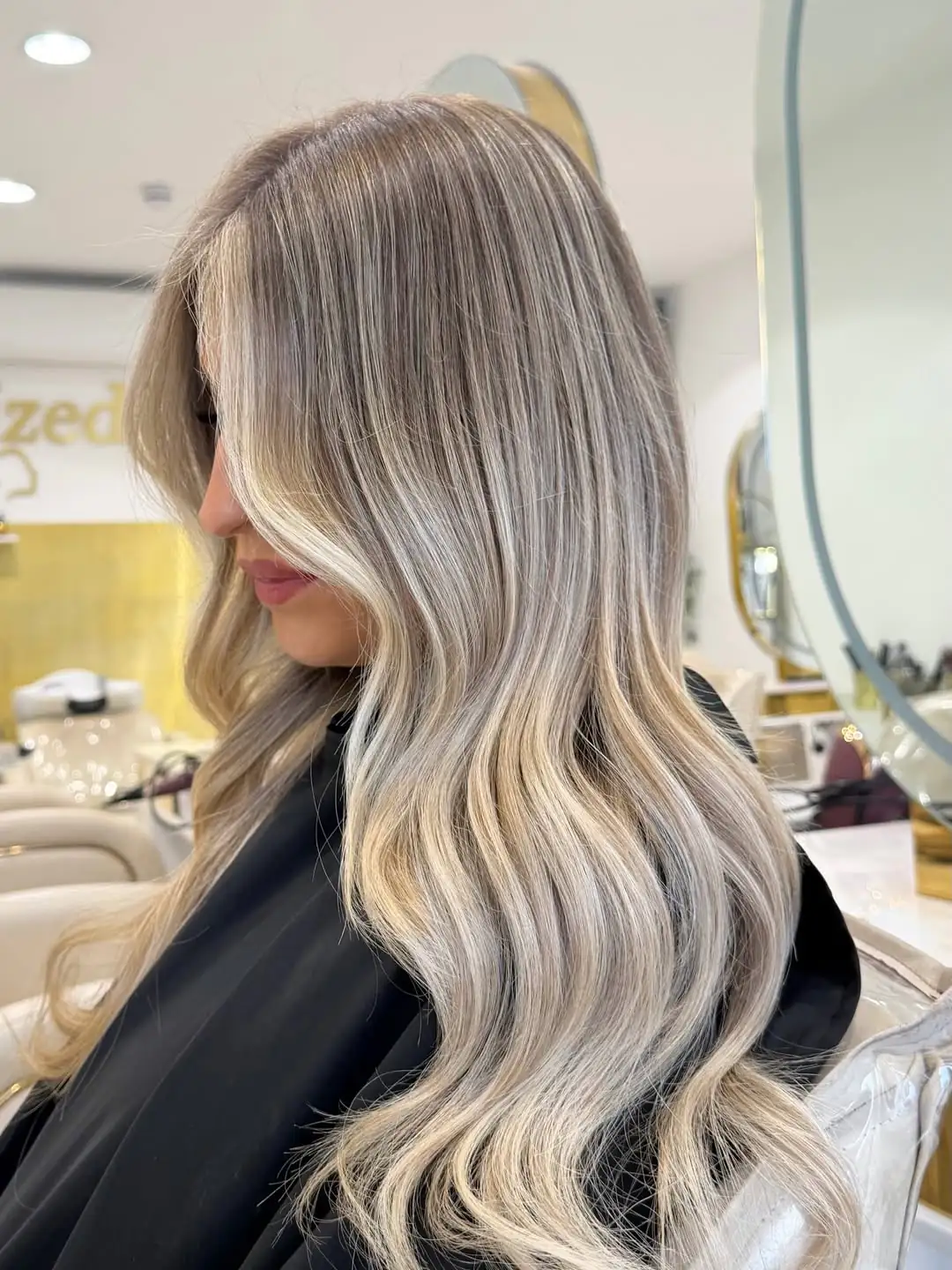 side view of a woman with long platinum blonde hair and loose waves