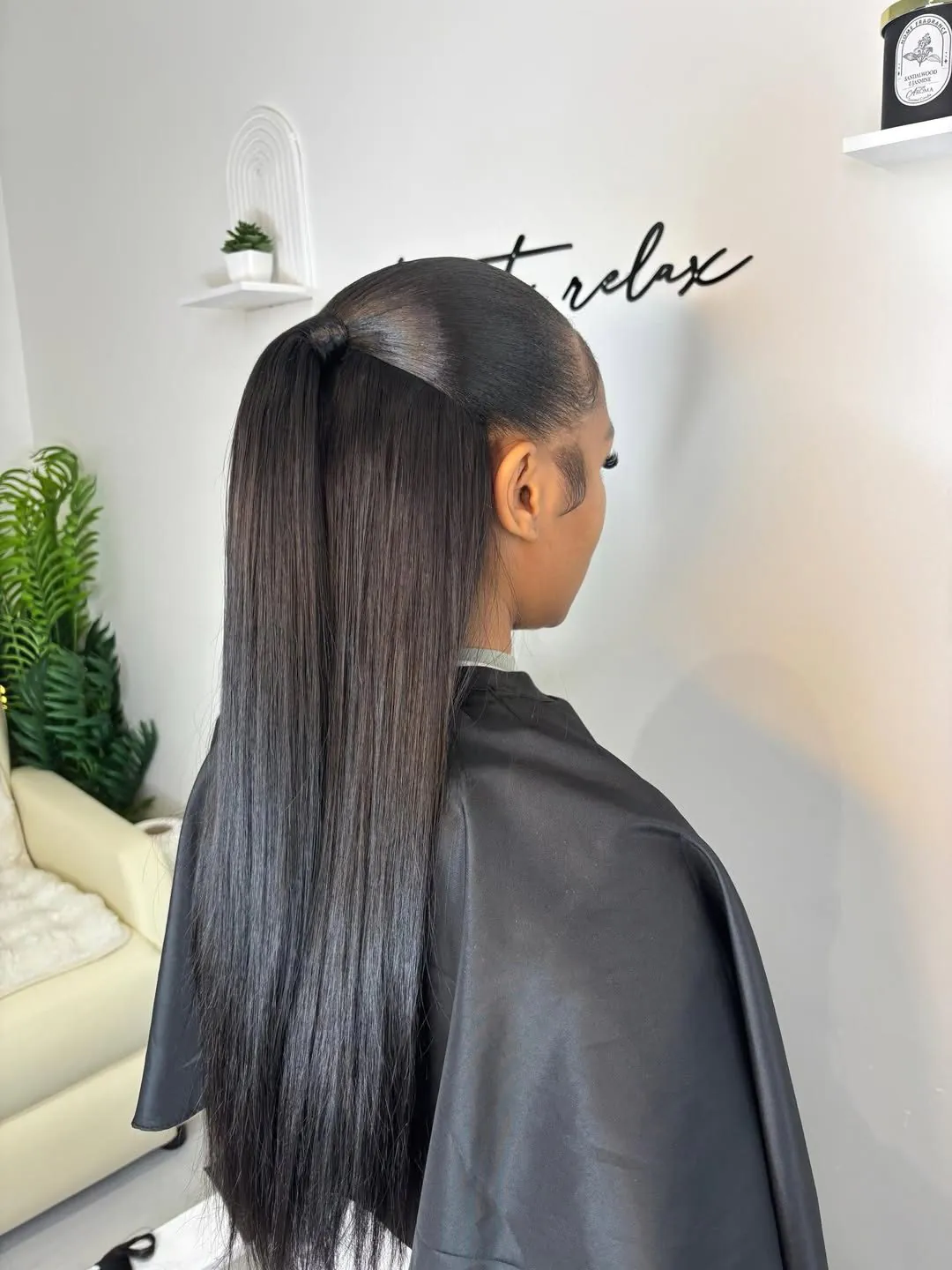 sleek long straight black hair styled in a high half-up ponytail at a salon.