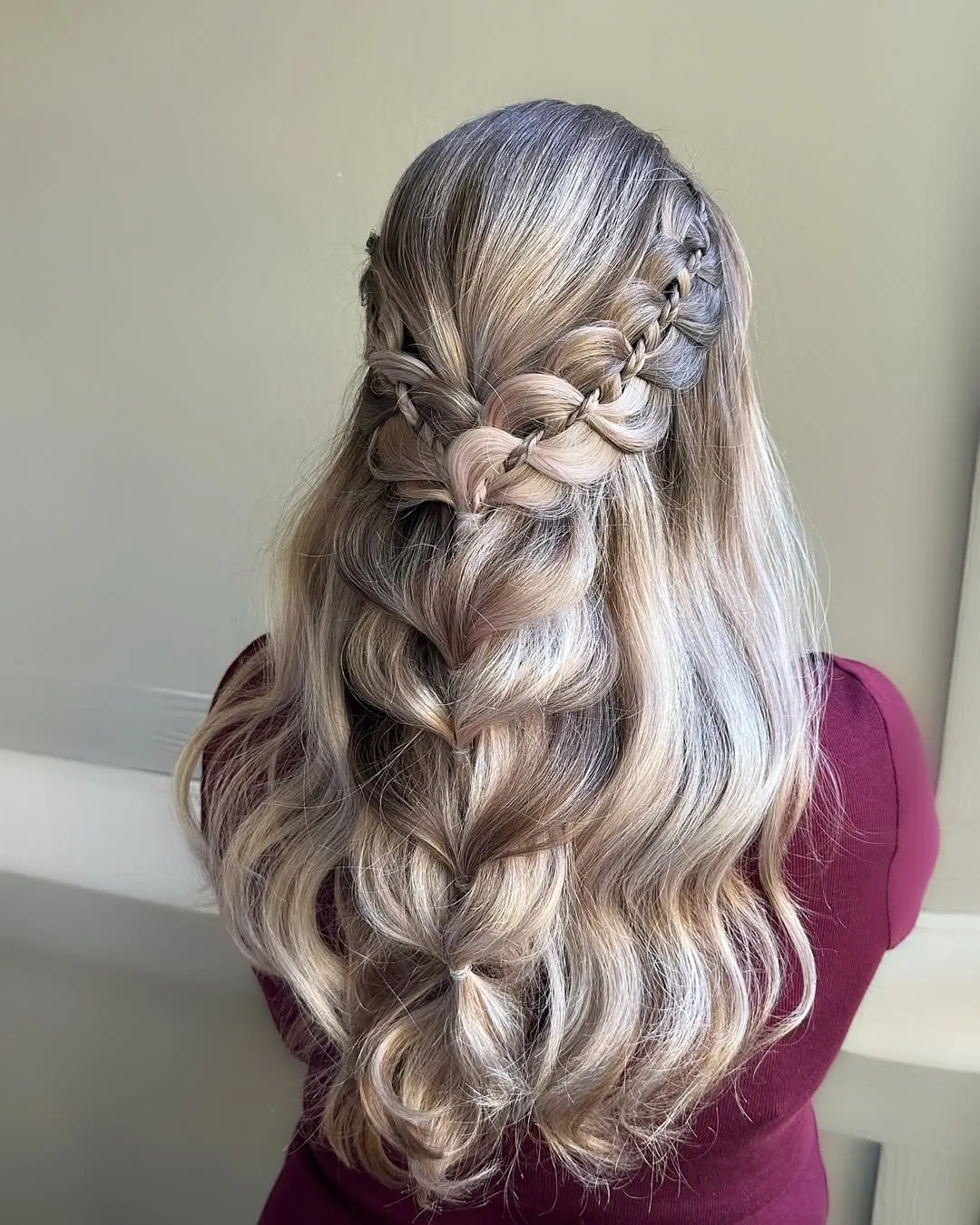 long blonde hair with silver tones styled in an intricate braided half-up half-down look.