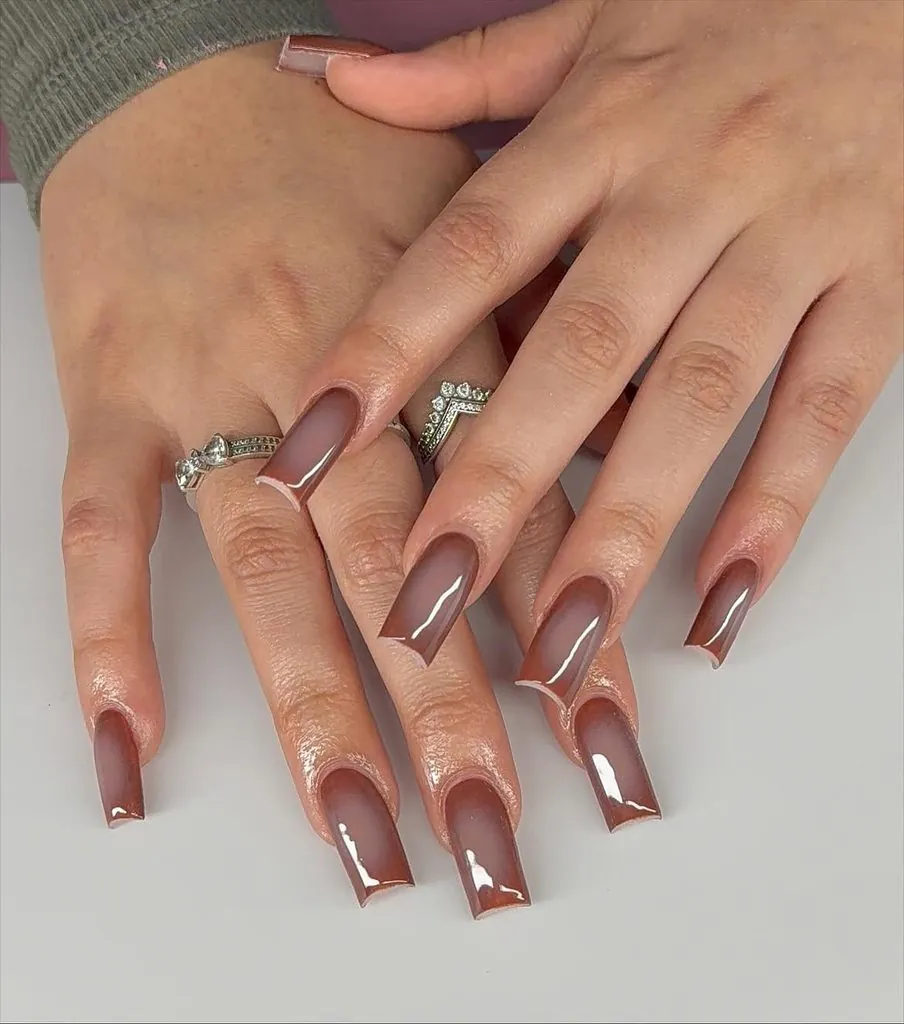 long square shaped acrylic nails with a glossy brown ombre jelly finish