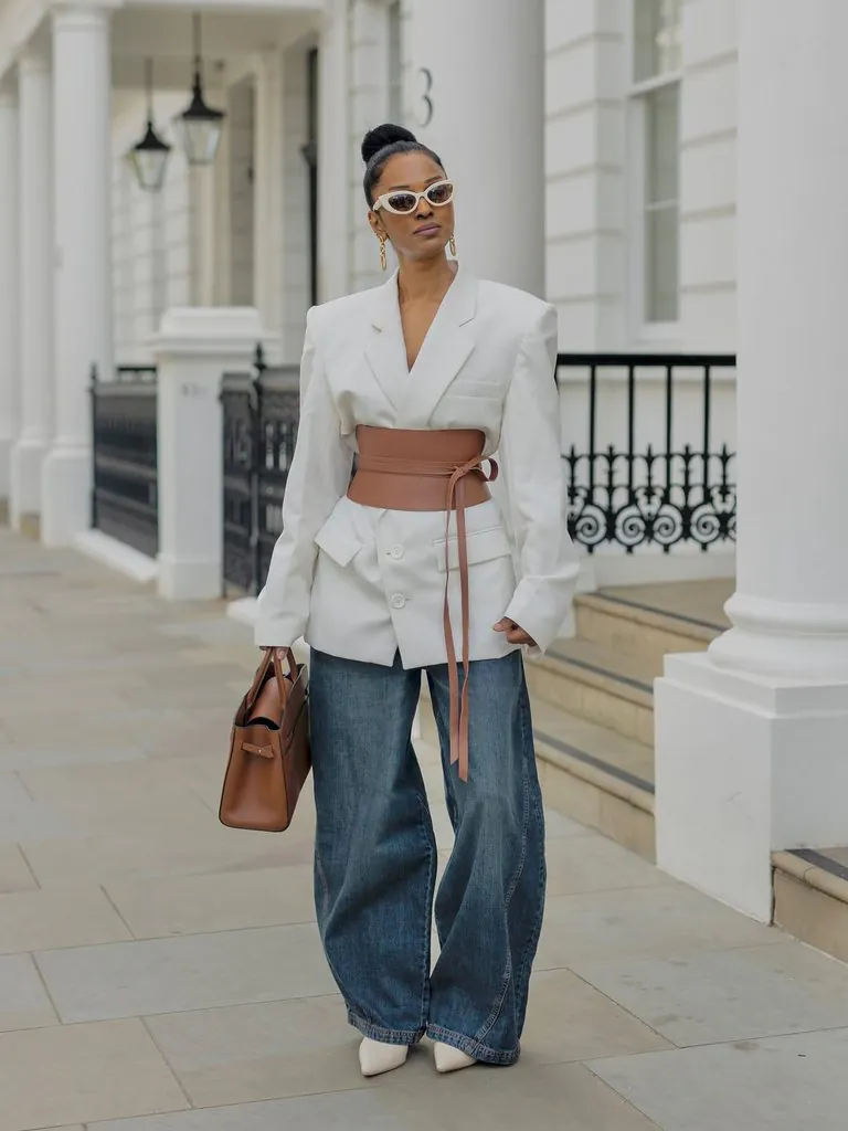 woman wearing oversized white blazer with wide belt and baggy jeans