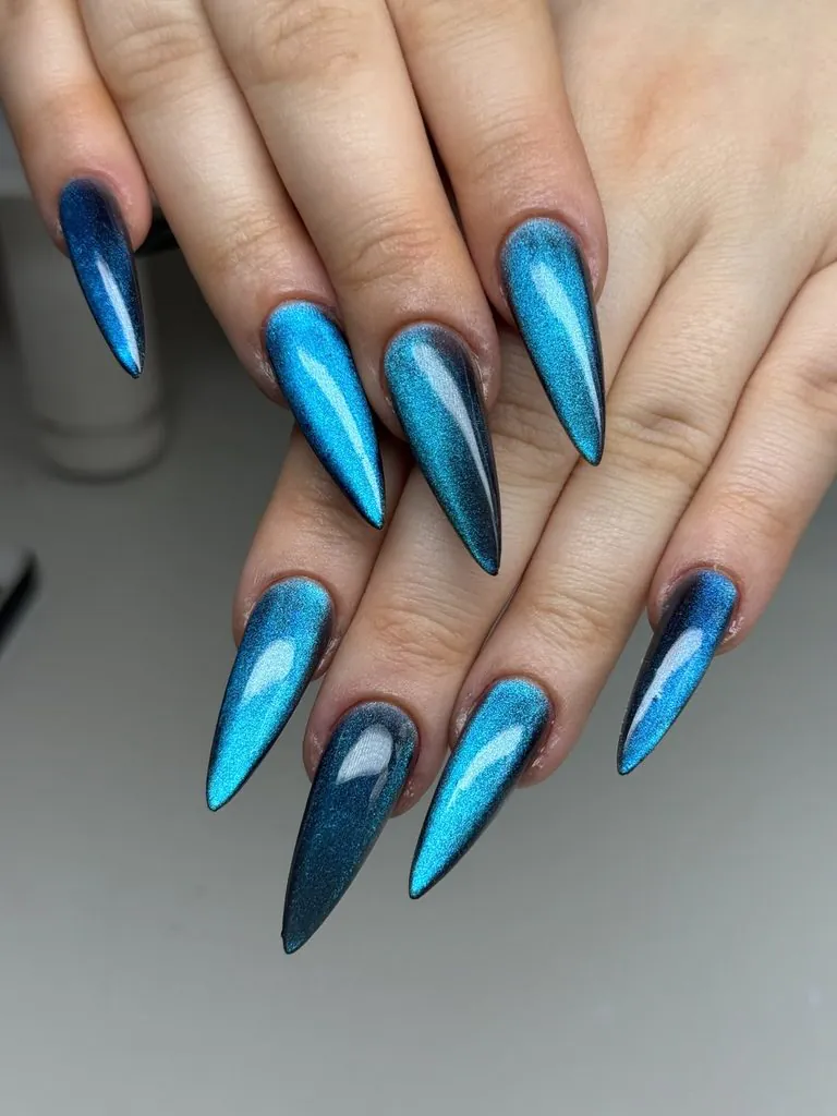 pointed stiletto manicure featuring shimmering blue and black magnetic cat-eye nails