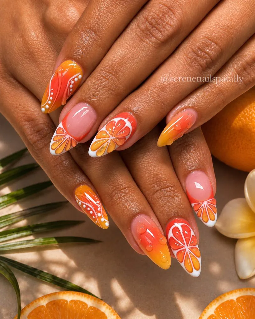 vibrant orange citrus slice nail art design on stiletto shaped manicured nails