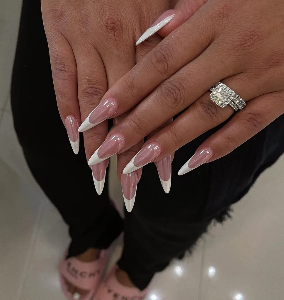long dramatic stiletto acrylic manicure featuring high smile line white french tip nails