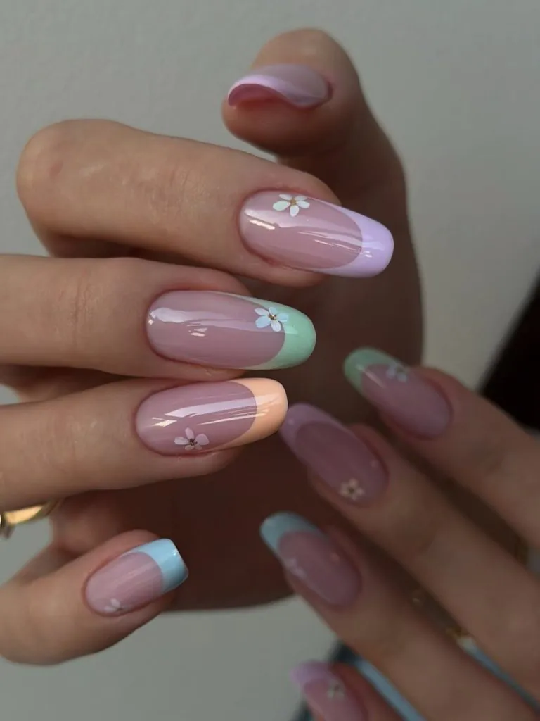 oval gel manicure with multi colored pastel french tip nails and white flower nail art