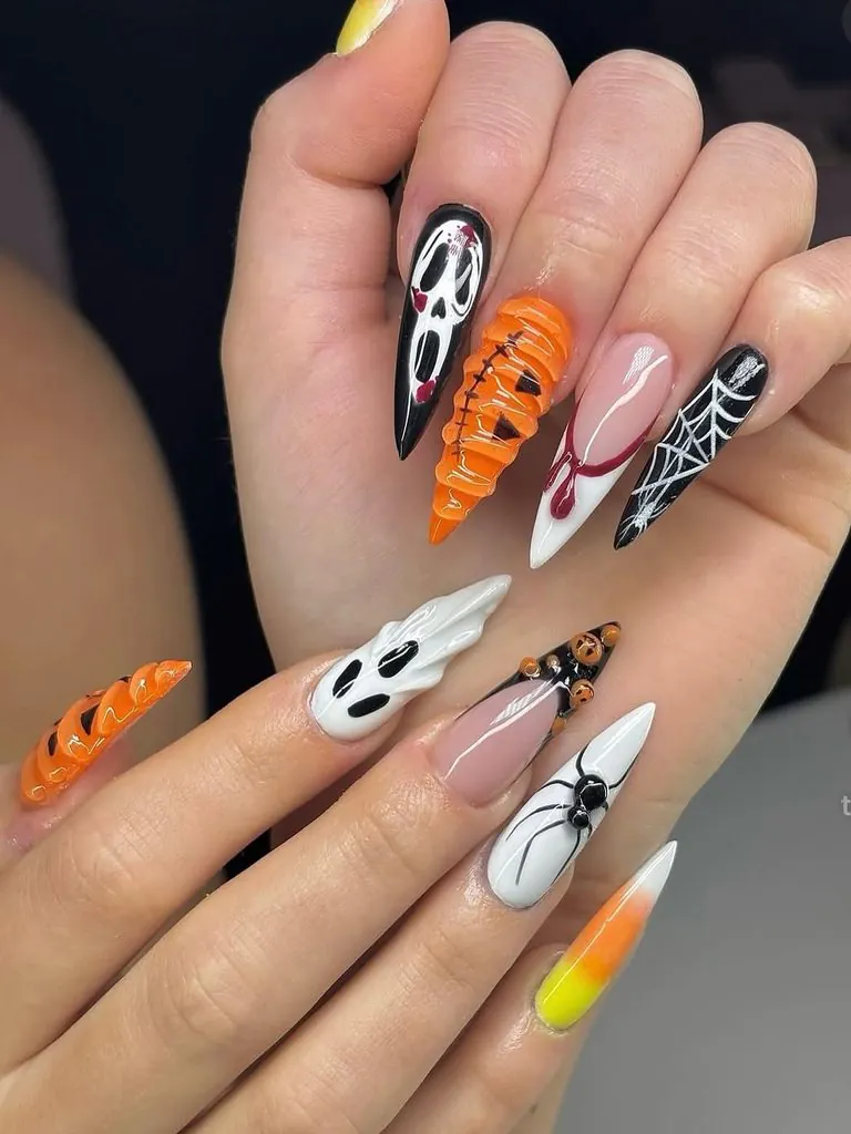 long stiletto halloween nails featuring ghost, pumpkin, spider, and candy corn art