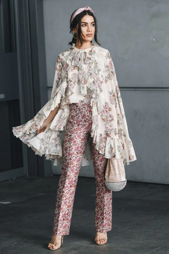 woman in a floral printed top and pants tea party outfit with ruffles