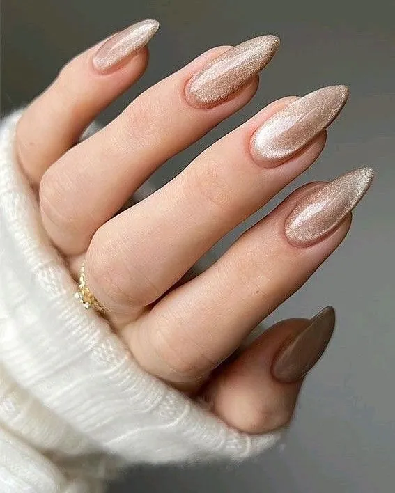 sparkly champagne gold magnetic cat eye chrome nails with white knitted sweater sleeve