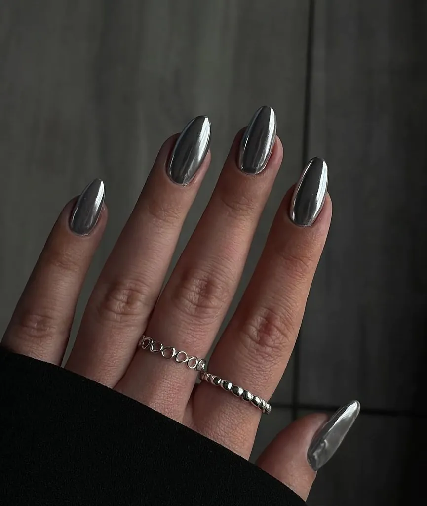 liquid silver metallic mirror chrome almond nails wearing stacked silver rings