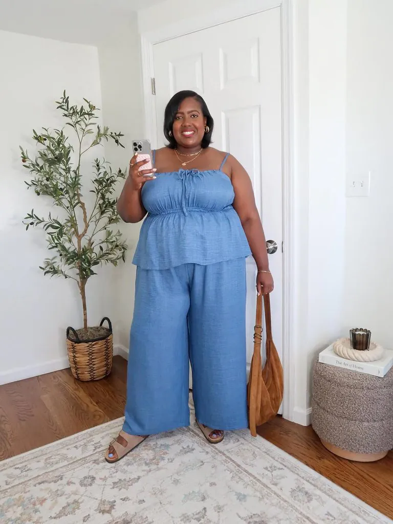 plus size woman wearing a blue matching set taking a mirror selfie