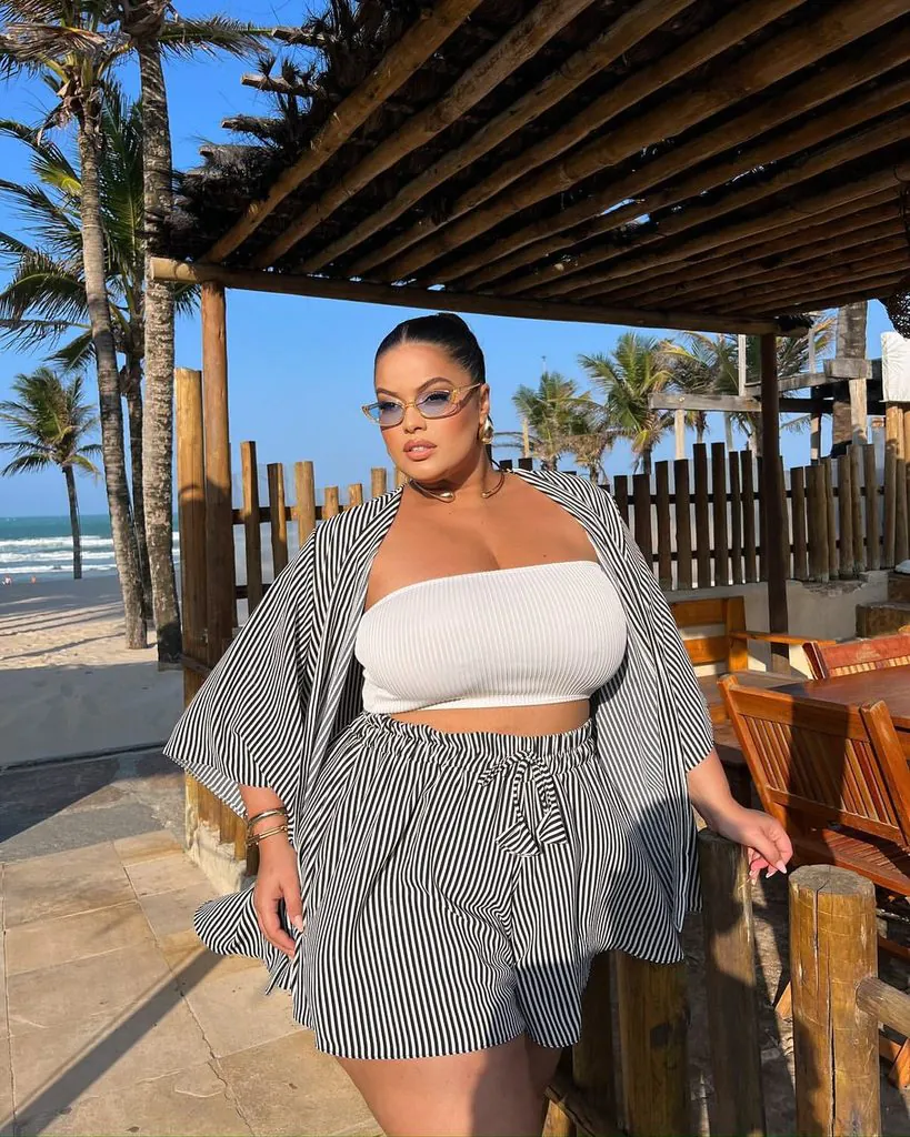 plus size woman wearing a striped matching set on a tropical beach