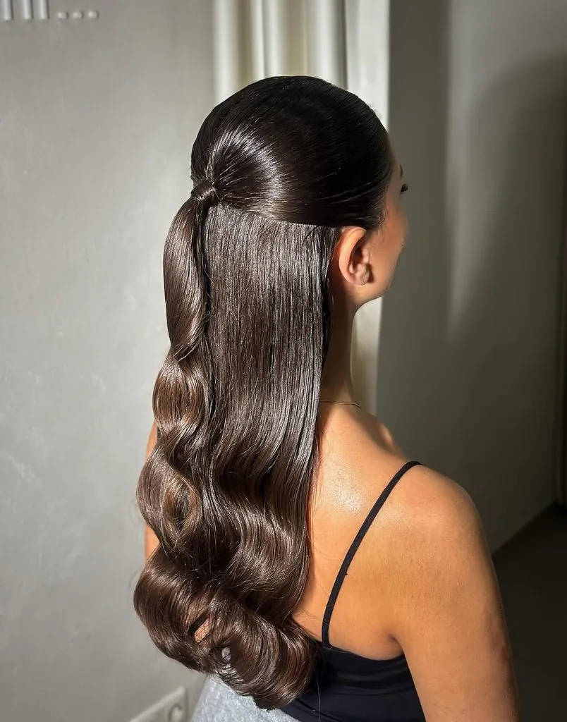 sleek brunette half-up ponytail with glossy waves falling down her back
