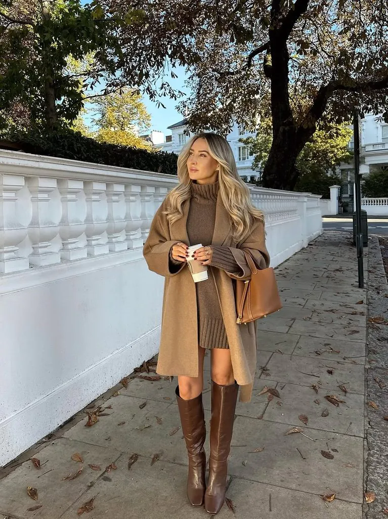 woman in camel coat brown sweater dress and knee high leather boots walking outside
