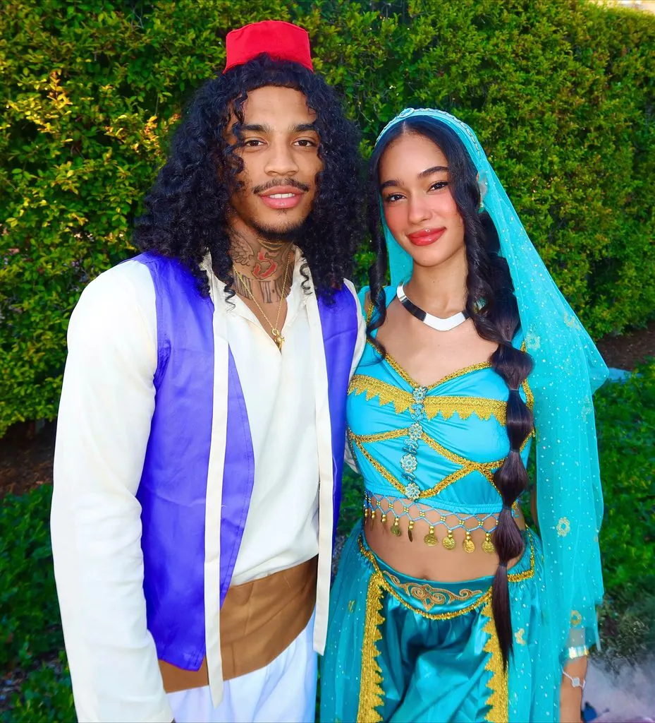 couple dressed as aladdin and princess jasmine halloween costumes posing outdoor