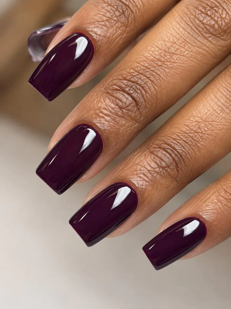 glossy deep plum purple square manicure on long dark skin hands